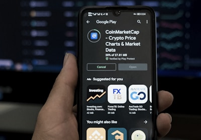 a person holding a cell phone in front of a computer