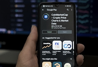 a person holding a cell phone in front of a computer